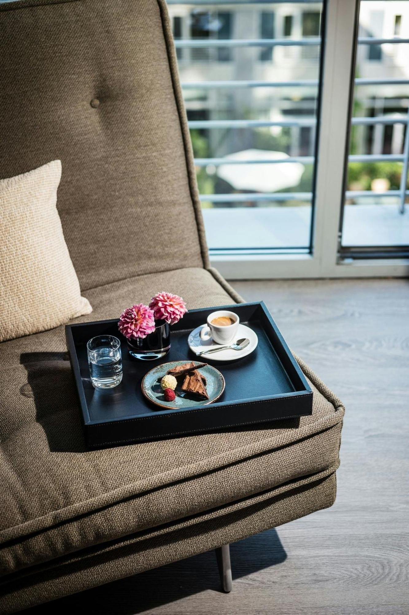 Le Meridien München Eksteriør billede A tray with a cup of coffee and a dessert